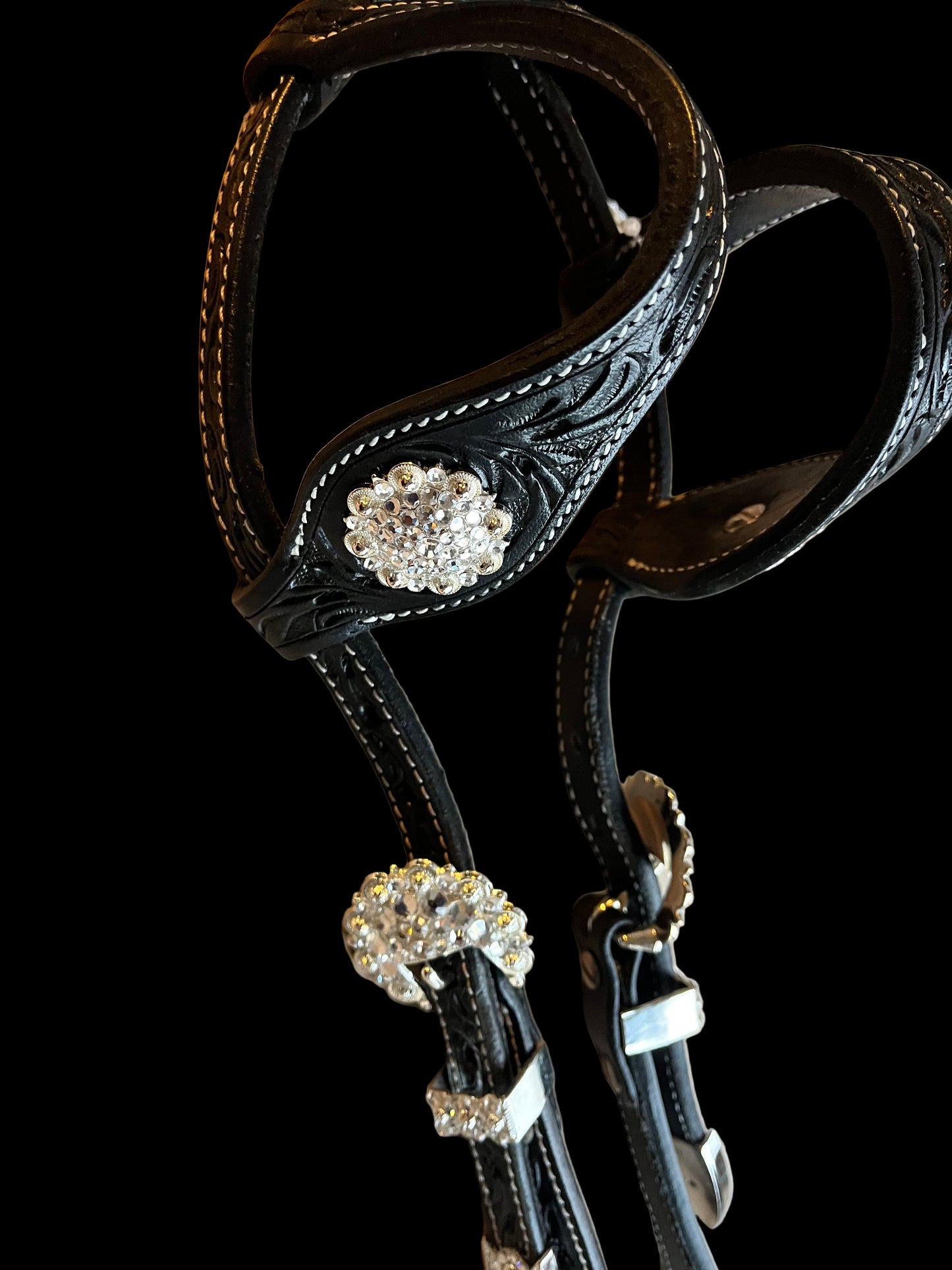 zoom sur les passants de la bride de show en cuir noir a strass blancs