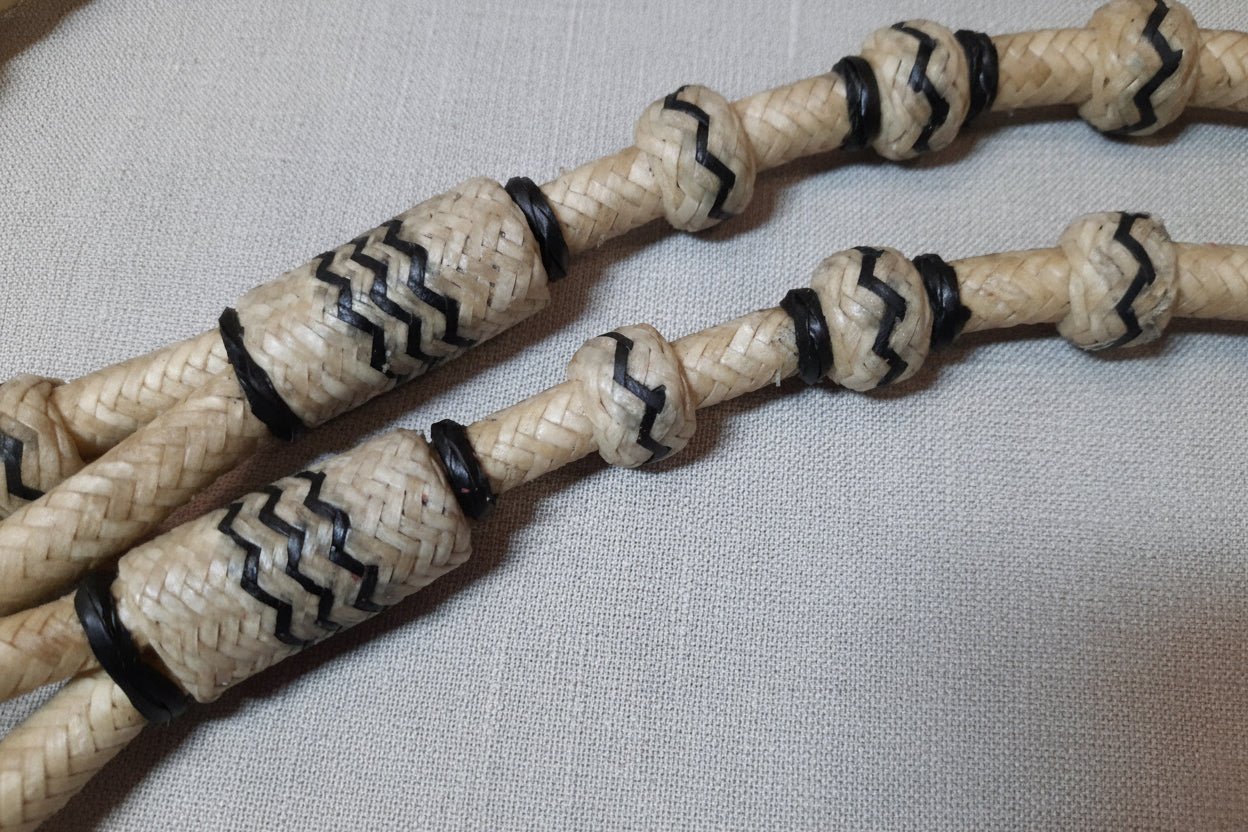 Rênes Romal entières BBR074 en rawhide naturel avec détails noirs, tressage style Oklahoma, idéales pour le show western et le ranch riding.
