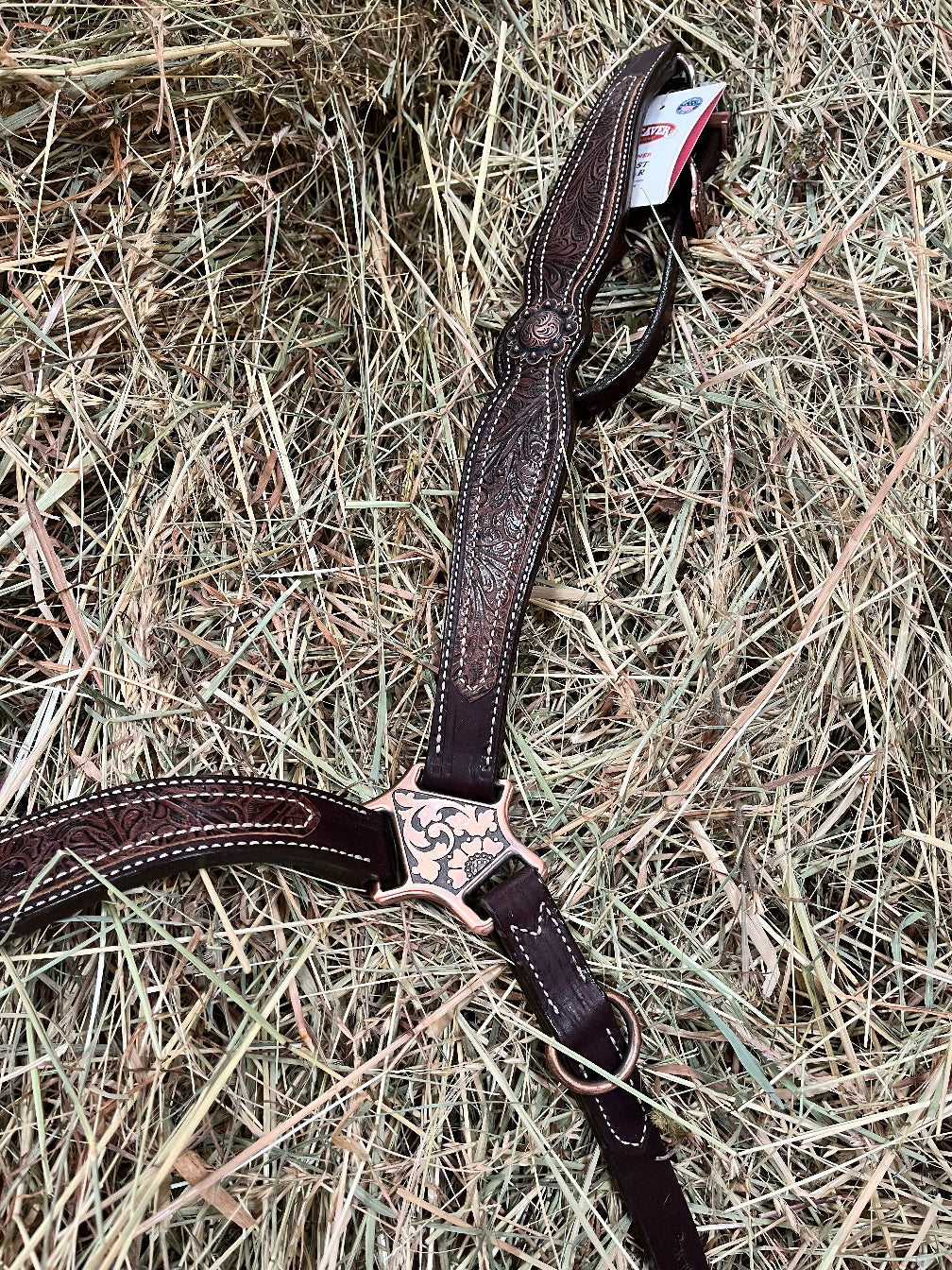 Poitrail western Weaver Equine en cuir anglais Havana, décoré d'un overlay floral marron et d'éléments floraux en finition cuivre antique, en situations dans du foin 